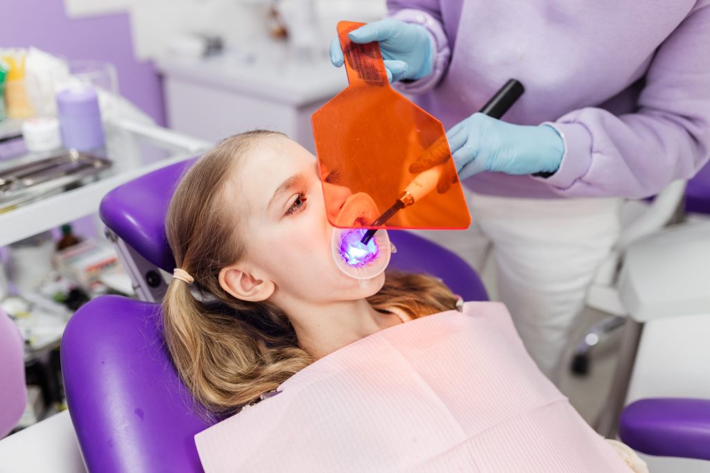 Young patient having a filling cured with a blue light