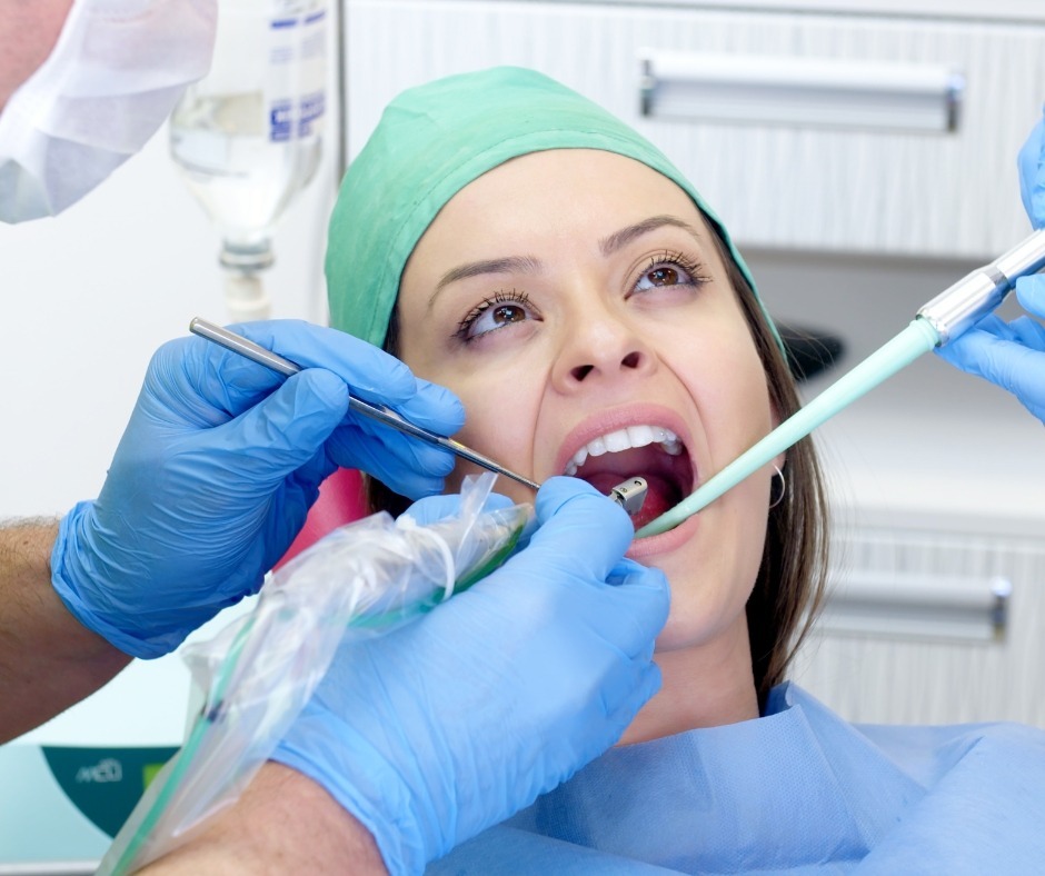 Dentist examining a patient's teeth before implant treatment
